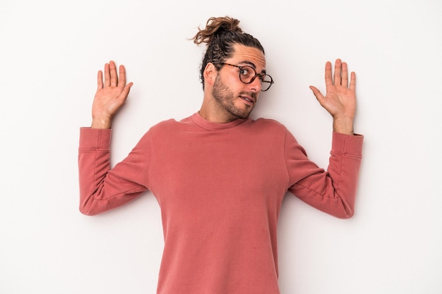 Young caucasian man isolated on white background being shocked due to an imminent danger