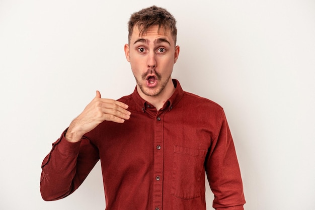 Young caucasian man isolated on white background cheerful smiles pointing to front.