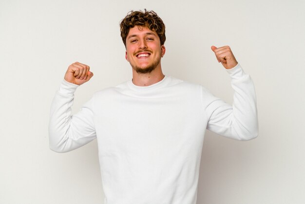 Photo young caucasian man isolated on white background cheering carefree and excited. victory concept.