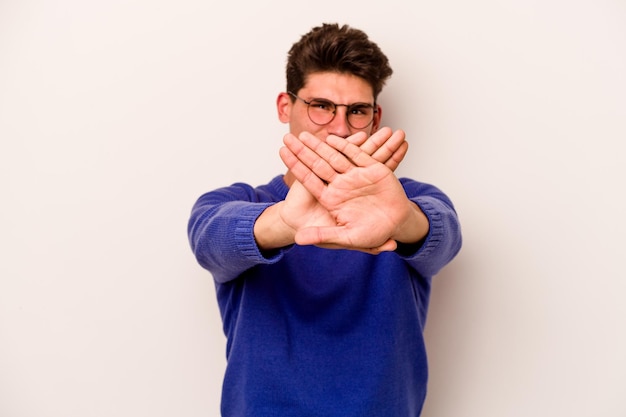 Foto giovane uomo caucasico isolato su sfondo bianco facendo un gesto di diniego