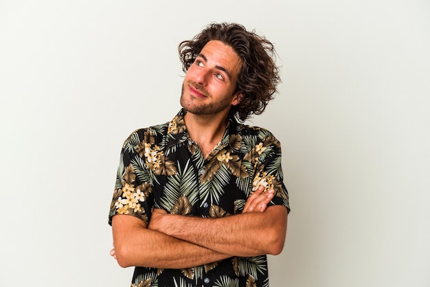 Young caucasian man isolated on white background dreaming of achieving goals and purposes