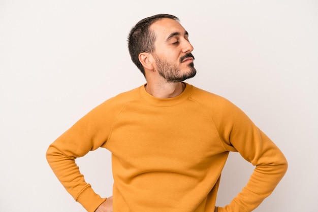 Young caucasian man isolated on white background dreaming of achieving goals and purposes