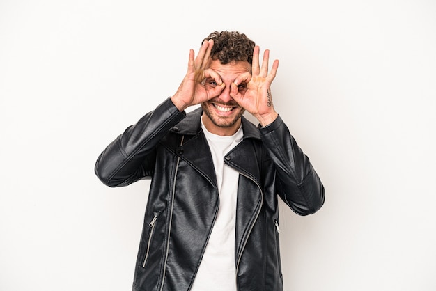 Young caucasian man isolated on white background excited keeping ok gesture on eye.