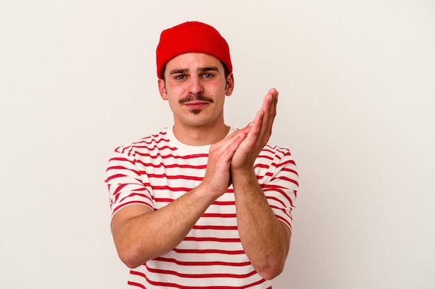 Young caucasian man isolated on white background feeling energetic and comfortable, rubbing hands confident.