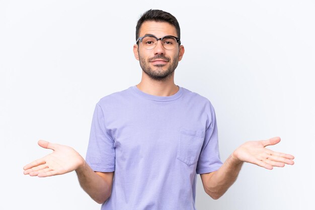 Young caucasian man isolated on white background having doubts