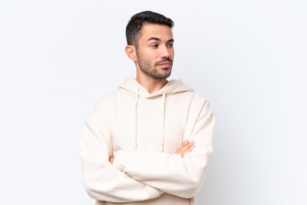 Young caucasian man isolated on white background keeping the arms crossed