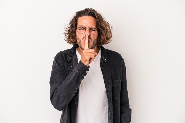 Foto giovane uomo caucasico isolato su sfondo bianco mantenendo un segreto o chiedendo silenzio.