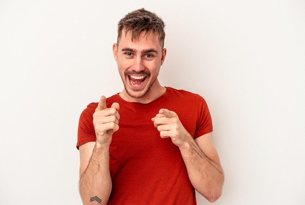 Young caucasian man isolated on white background laughs happily and has fun keeping hands on stomach.