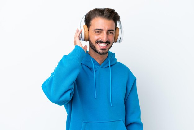 Young caucasian man isolated on white background listening music