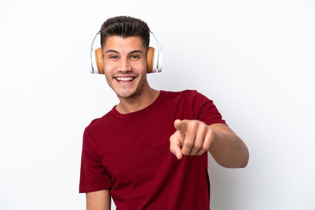 Young caucasian man isolated on white background listening music