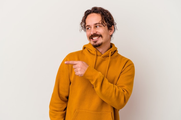 Young caucasian man isolated on white background looks aside smiling, cheerful and pleasant.