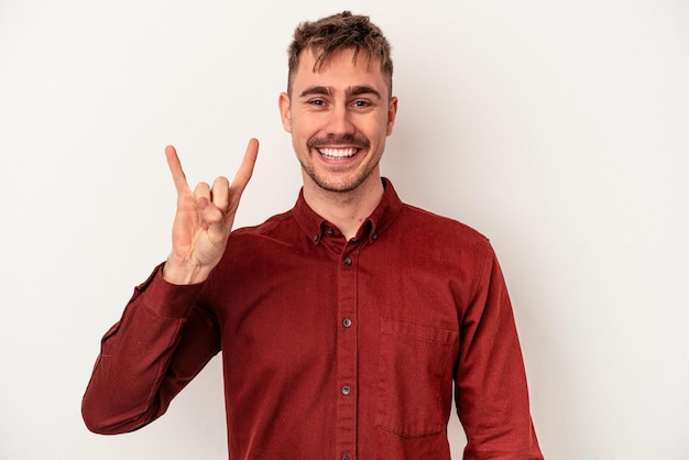 Young caucasian man isolated on white background pointing with forefingers to a copy space, expressing excitement and desire.