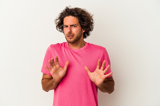 Young caucasian man isolated on white background rejecting someone showing a gesture of disgust.