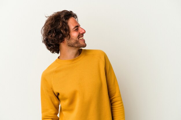 Young caucasian man isolated on white background relaxed and happy laughing, neck stretched showing teeth.