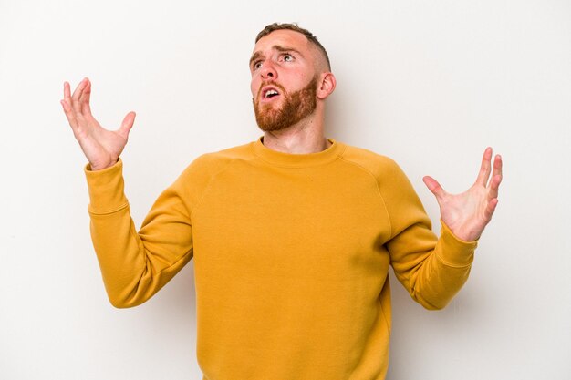 Young caucasian man isolated on white background screaming to the sky, looking up, frustrated.