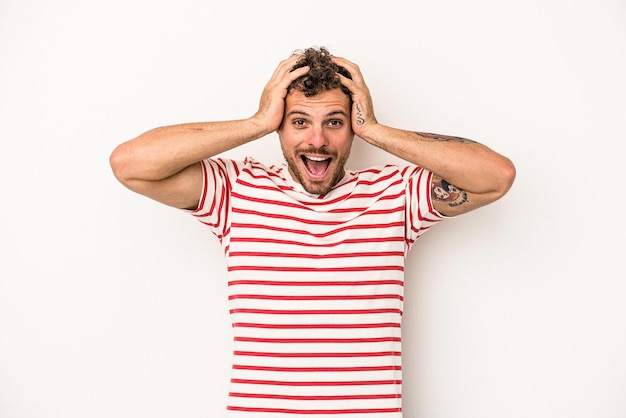 Young caucasian man isolated on white background screaming, very excited, passionate, satisfied with something.