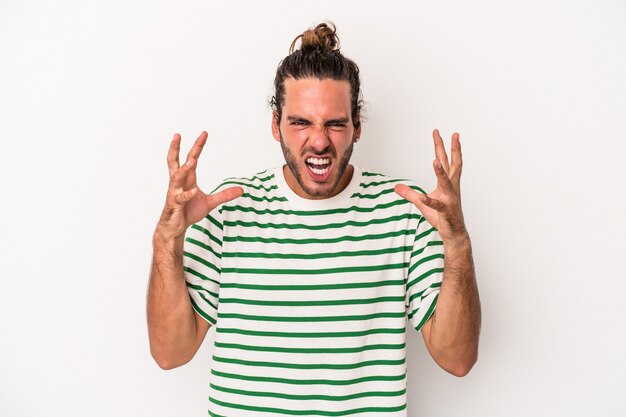 Young caucasian man isolated on white background screaming with rage.