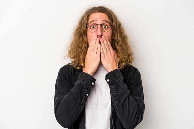 Young caucasian man isolated on white background shocked covering mouth with hands