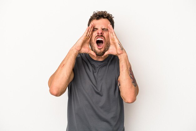 Young caucasian man isolated on white background shouting excited to front.