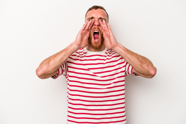 Young caucasian man isolated on white background shouting excited to front.