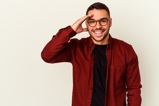 Young caucasian man isolated on white background shouts loud, keeps eyes opened and hands tense.