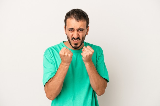 Young caucasian man isolated on white background showing fist to camera, aggressive facial expression.