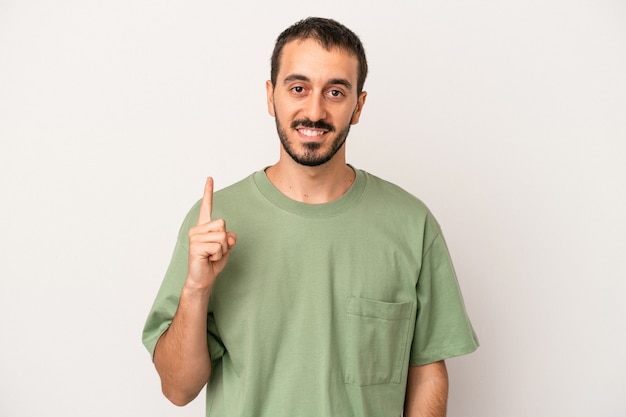 Young caucasian man isolated on white background showing number one with finger.