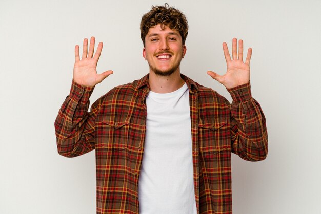 Young caucasian man isolated on white background showing number ten with hands.