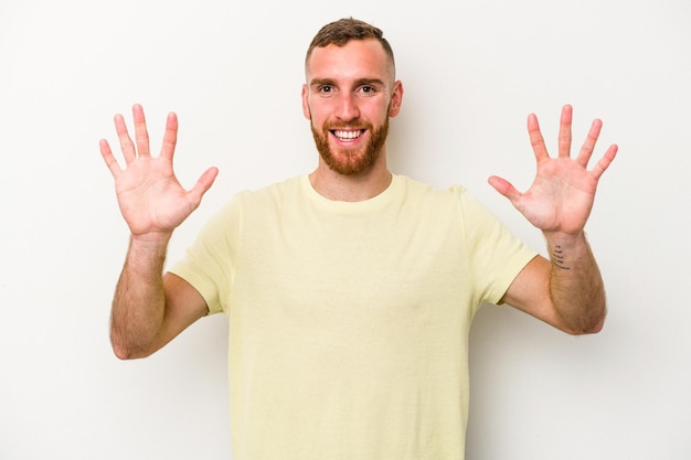 Young caucasian man isolated on white background showing number ten with hands.