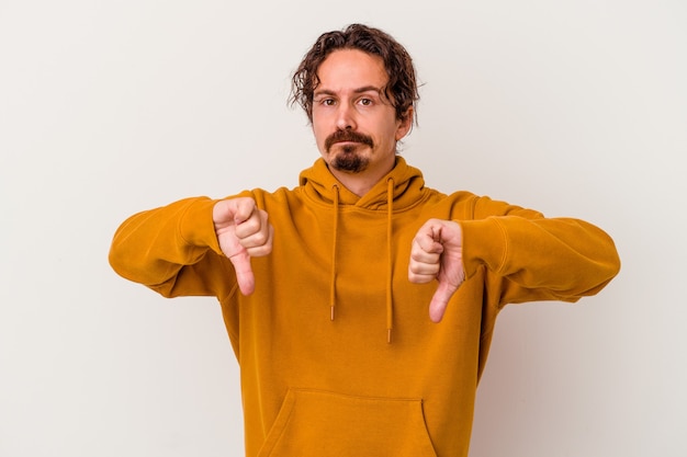 Young caucasian man isolated on white background showing thumb down, disappointment concept.