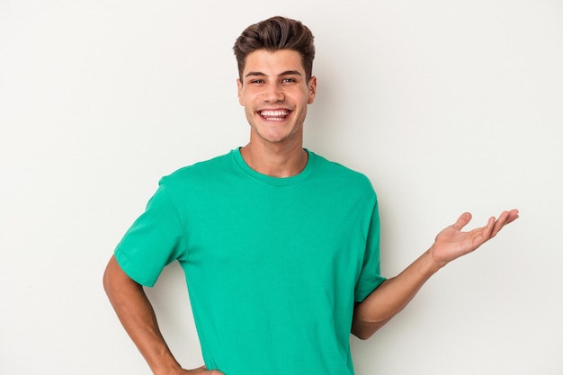 Young caucasian man isolated on white background showing a welcome expression.