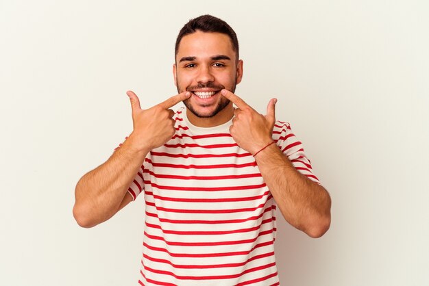 Young caucasian man isolated on white background smiles, pointing fingers at mouth.