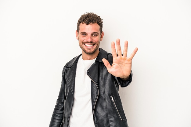 Young caucasian man isolated on white background smiling cheerful showing number five with fingers.