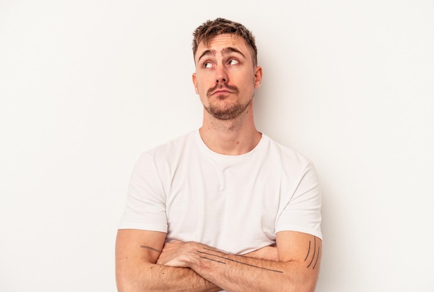 Young caucasian man isolated on white background smiling cheerfully pointing with forefinger away.