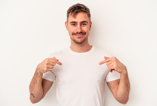 Young caucasian man isolated on white background smiling and raising thumb up