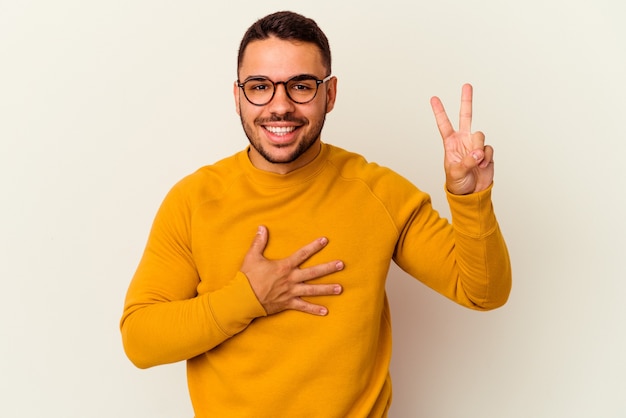 Young caucasian man isolated on white background taking an oath, putting hand on chest.