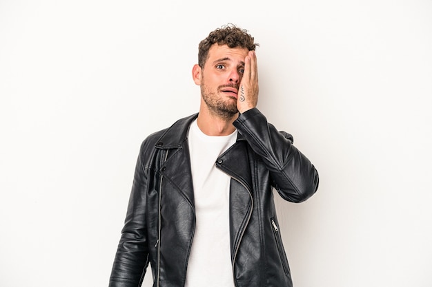 Young caucasian man isolated on white background tired and very sleepy keeping hand on head.