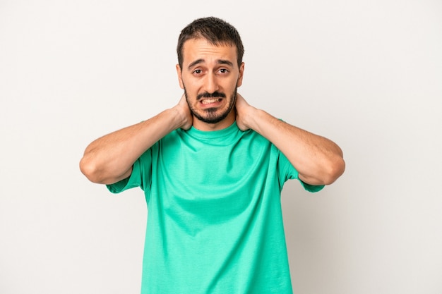 Young caucasian man isolated on white background touching back of head, thinking and making a choice.