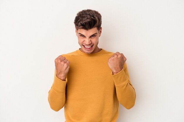 Young caucasian man isolated on white background upset screaming with tense hands.