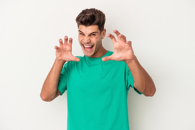 Young caucasian man isolated on white background upset screaming with tense hands.