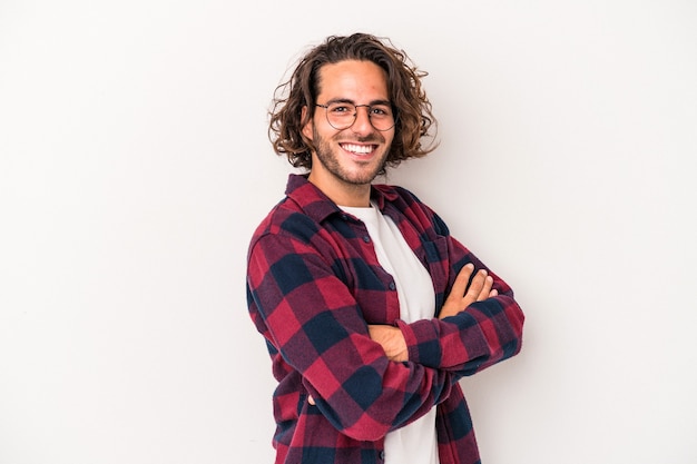 Young caucasian man isolated on white background who feels confident, crossing arms with determination.