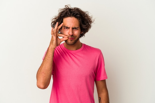 Young caucasian man isolated on white background with fingers on lips keeping a secret.