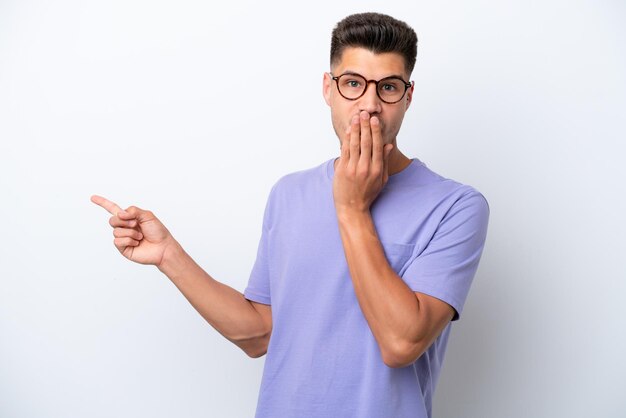 Young caucasian man isolated on white background with surprise expression while pointing side