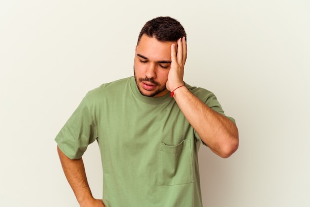 Young caucasian man isolated on white tired and very sleepy keeping hand on head.