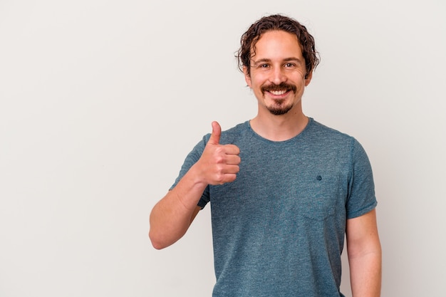 Young caucasian man isolated on white wall smiling and raising thumb up