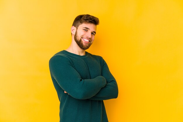 Young caucasian man isolated on yellow background happy, smiling and cheerful.