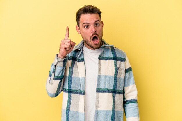 Young caucasian man isolated on yellow background having an idea, inspiration concept.