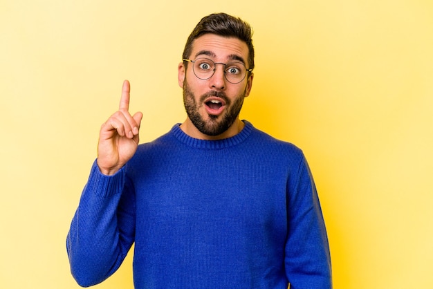 Young caucasian man isolated on yellow background having an idea inspiration concept