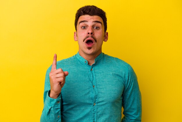 Young caucasian man isolated on yellow background having some great idea, concept of creativity.