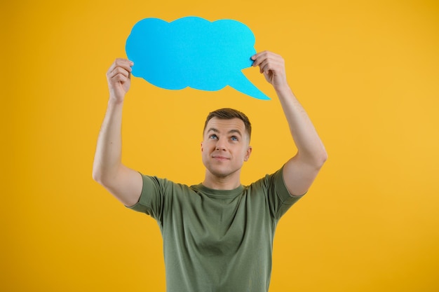 Young caucasian man isolated on yellow background holding a thinking speech bubble and doing OK sign